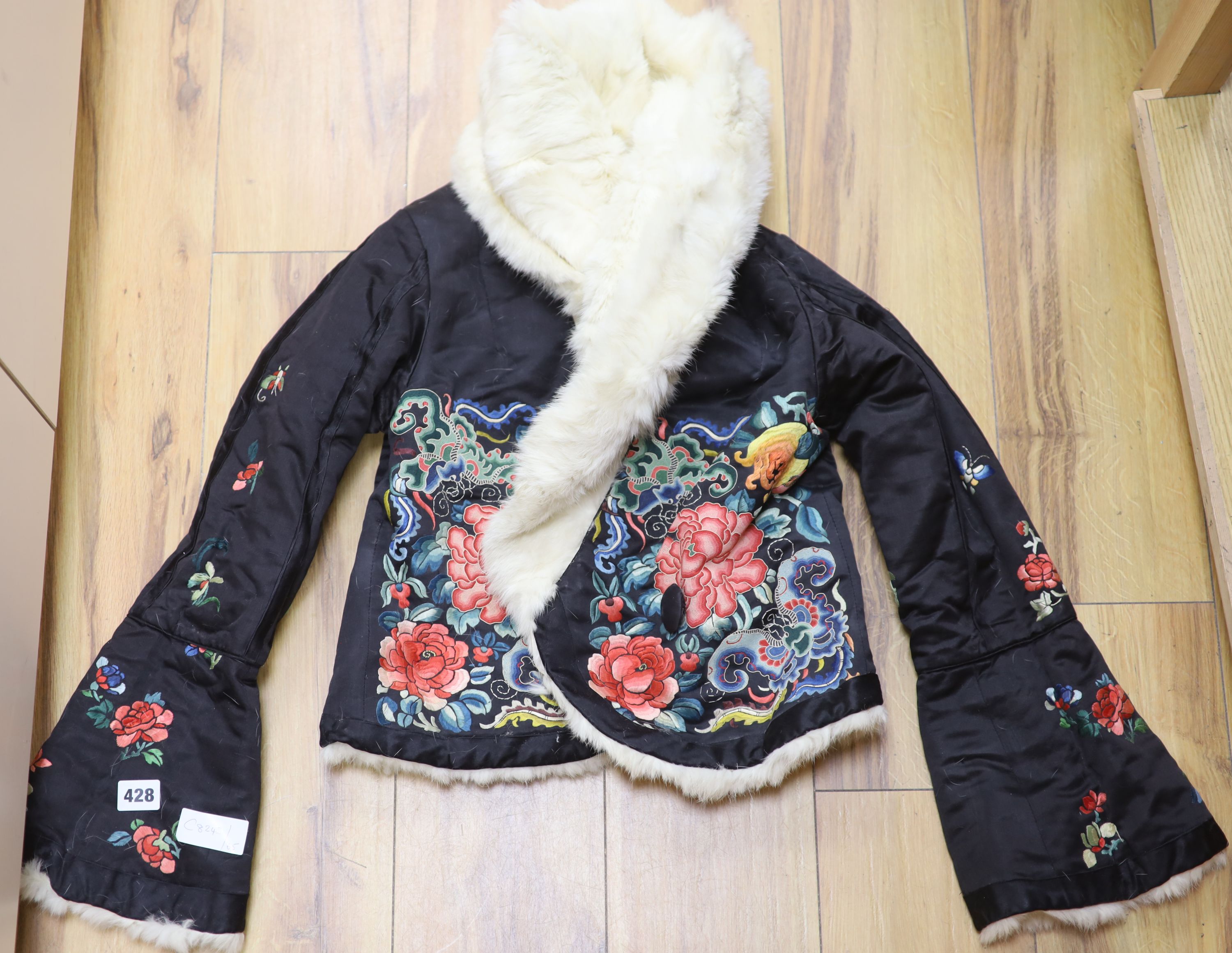 A Chinese black silk polychrome embroidered childs / ladies jacket, embroidered in Chinese knot and stem stitch